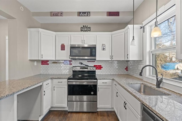 kitchen with backsplash, dark wood finished floors, stainless steel appliances, white cabinetry, and a sink