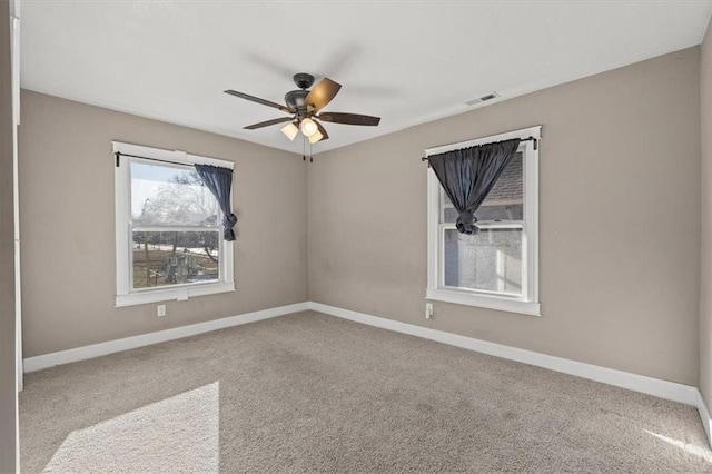 unfurnished room featuring visible vents, carpet flooring, baseboards, and ceiling fan