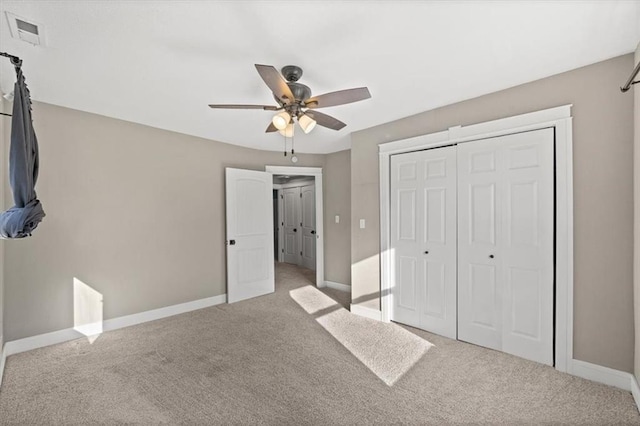 unfurnished bedroom featuring a ceiling fan, baseboards, visible vents, a closet, and carpet flooring