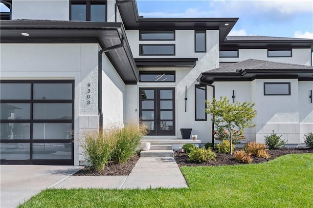 doorway to property with a garage, french doors, a shingled roof, and stucco siding