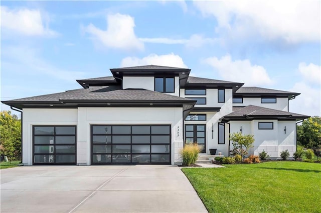 prairie-style home with an attached garage, driveway, a front lawn, and stucco siding