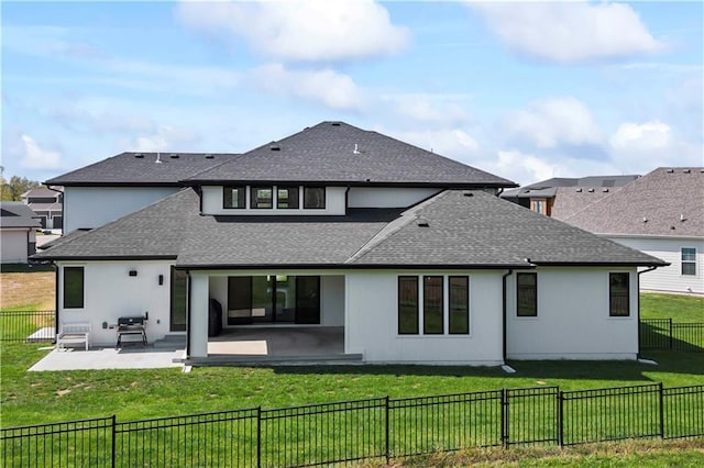 back of house featuring a shingled roof, a patio area, a fenced backyard, and a yard