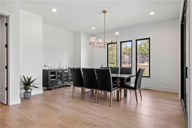 dining space with light wood-style floors, recessed lighting, a chandelier, and baseboards