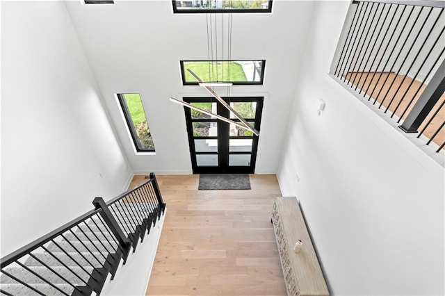 entrance foyer with stairway, a high ceiling, and wood finished floors