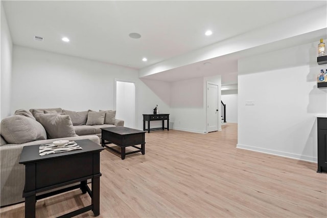 living room featuring baseboards, light wood finished floors, visible vents, and recessed lighting