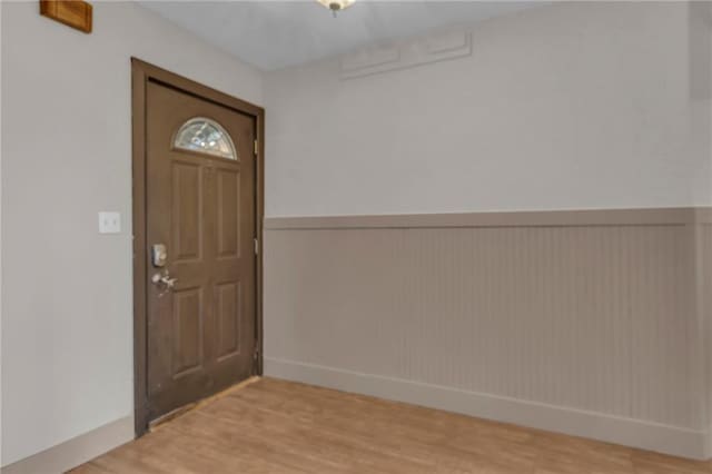 entryway with a wainscoted wall and light wood-style floors