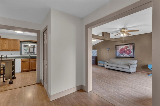 interior space with light wood-type flooring, a sink, and baseboards