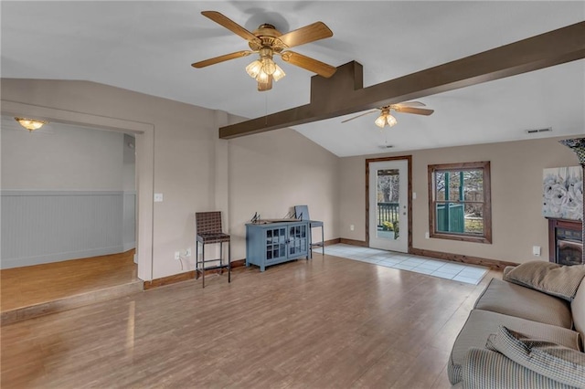 living room featuring vaulted ceiling with beams, visible vents, ceiling fan, wood finished floors, and baseboards