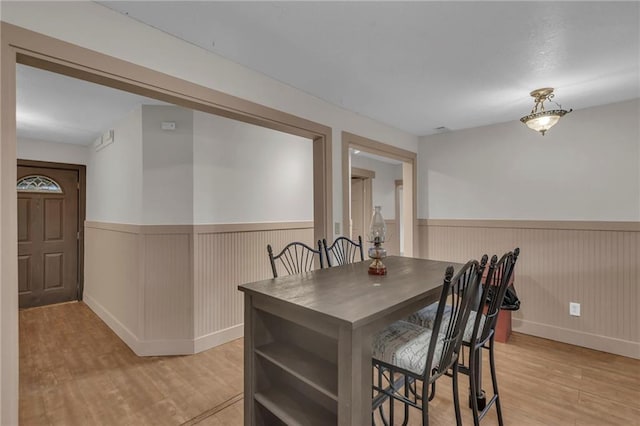 dining area featuring wainscoting and light wood-style floors