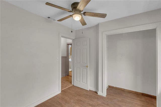 unfurnished bedroom featuring visible vents, a ceiling fan, light wood-style flooring, and baseboards