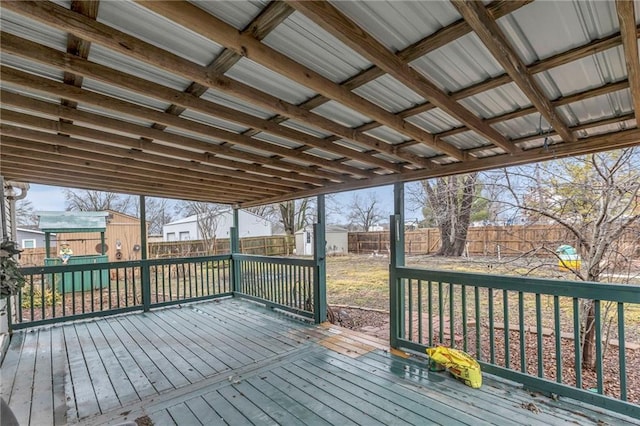 wooden terrace with a storage shed, an outbuilding, and a fenced backyard