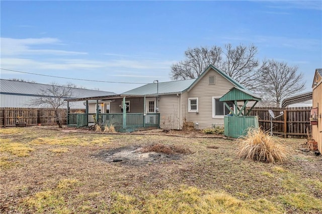 back of house with central air condition unit, a fenced backyard, and metal roof