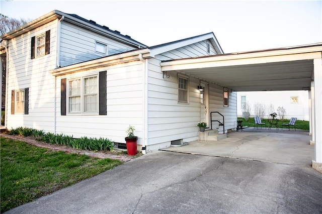 view of side of property with an attached carport and concrete driveway