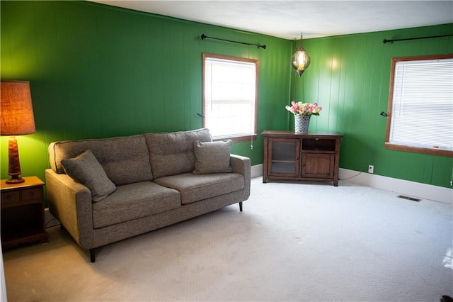carpeted living area with baseboards and visible vents