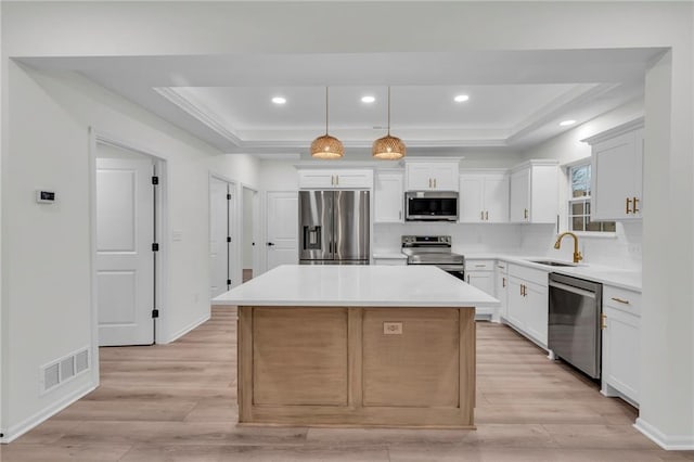 kitchen featuring a sink, a tray ceiling, visible vents, and stainless steel appliances