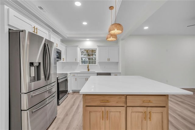 kitchen featuring a sink, decorative backsplash, light countertops, stainless steel appliances, and light wood-type flooring