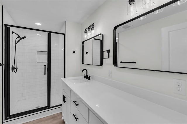 bathroom featuring visible vents, a shower stall, recessed lighting, wood finished floors, and vanity