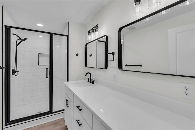 full bathroom with vanity, wood finished floors, visible vents, recessed lighting, and a shower stall
