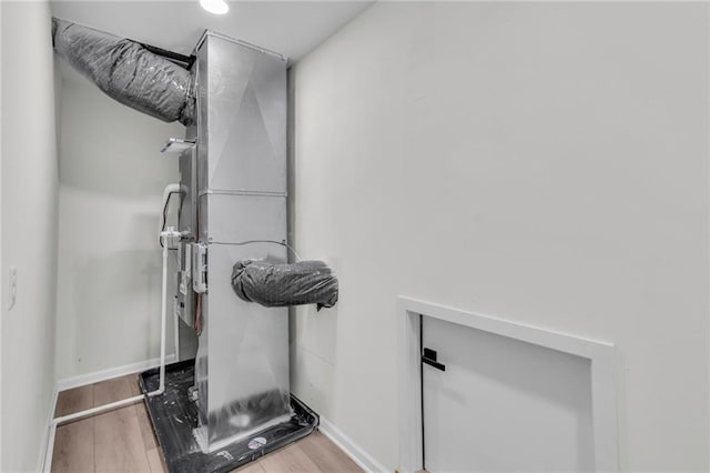 workout room with baseboards and wood finished floors