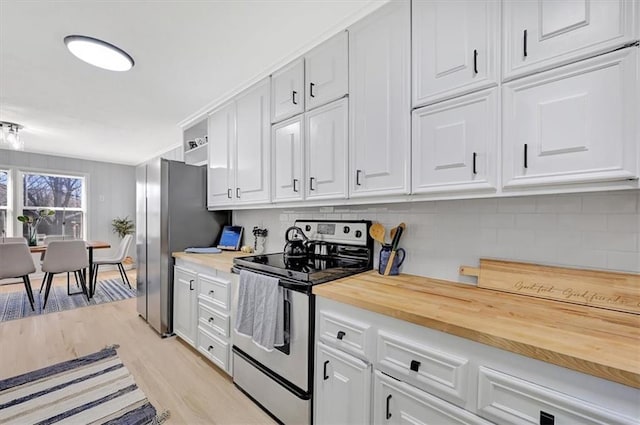 kitchen featuring light wood finished floors, butcher block countertops, decorative backsplash, appliances with stainless steel finishes, and white cabinets