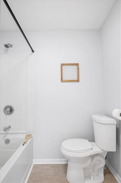 bathroom featuring baseboards, toilet, wood finished floors, and  shower combination