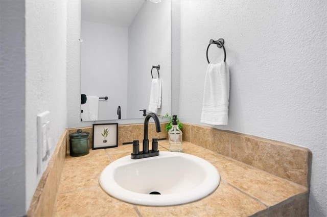 bathroom with vanity and a textured wall