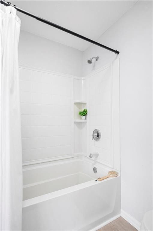 bathroom featuring baseboards and shower / bath combo