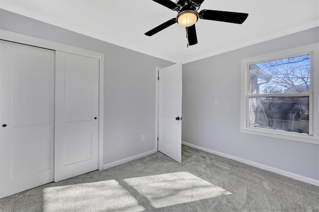 unfurnished bedroom featuring a closet, ceiling fan, baseboards, and carpet floors