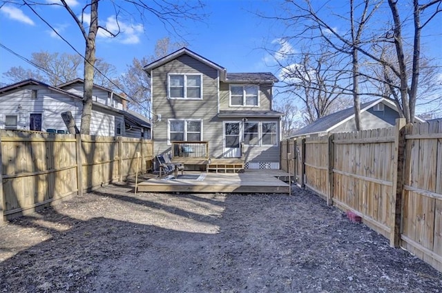 back of property with a deck and a fenced backyard