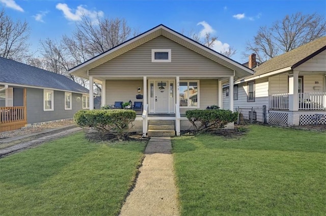 bungalow with covered porch and a front yard