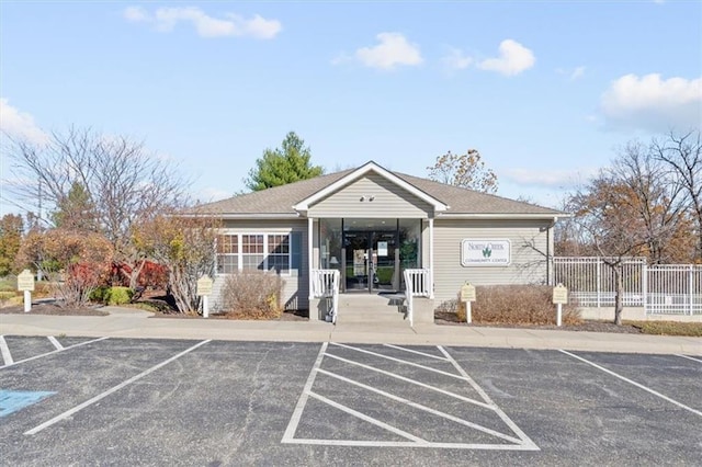 view of property with uncovered parking and fence