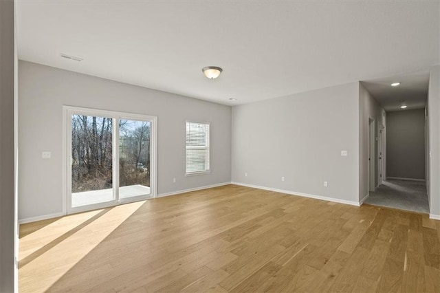 empty room featuring light wood finished floors, baseboards, visible vents, and recessed lighting