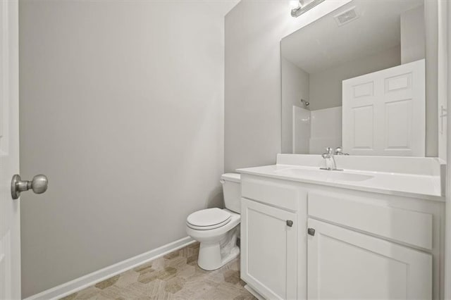 full bath featuring toilet, vanity, visible vents, baseboards, and a shower