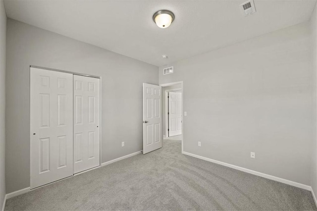 unfurnished bedroom featuring carpet, a closet, visible vents, and baseboards