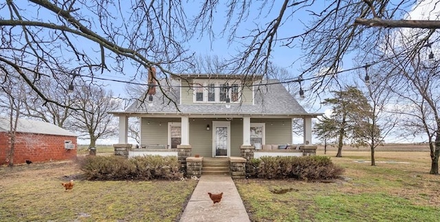 bungalow featuring roof with shingles, a porch, and a front yard