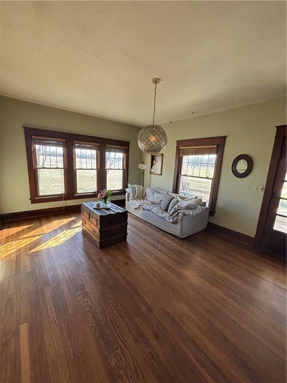 unfurnished living room featuring dark wood-style floors and baseboards