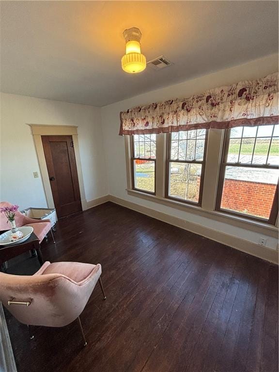 interior space featuring a healthy amount of sunlight, dark wood-style flooring, visible vents, and baseboards