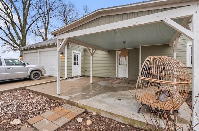 property entrance with a carport, driveway, and a garage