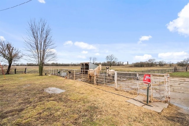 view of yard featuring an outbuilding, an exterior structure, and a rural view