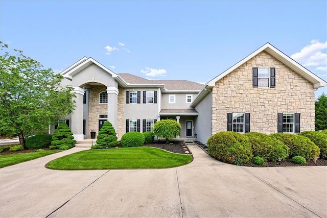 view of front of property with stone siding, stucco siding, and a front lawn