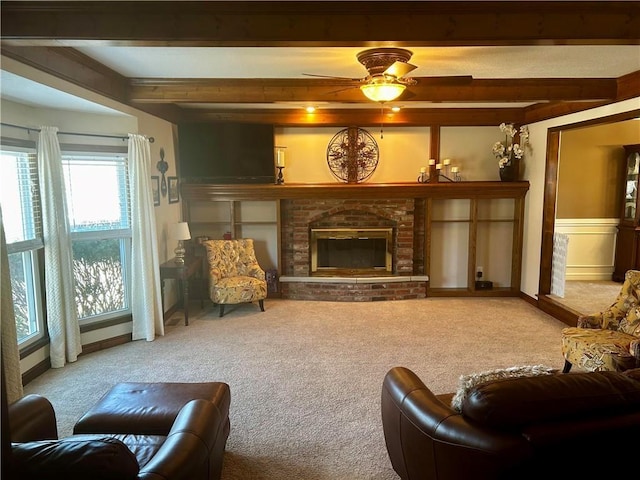 living room featuring beamed ceiling, carpet floors, and a brick fireplace