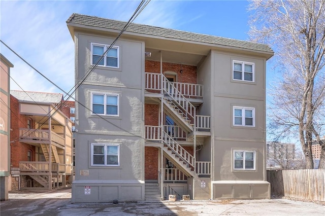 exterior space with fence, stairway, and brick siding