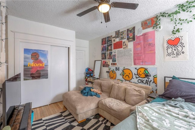 interior space featuring a textured ceiling, ceiling fan, and wood finished floors