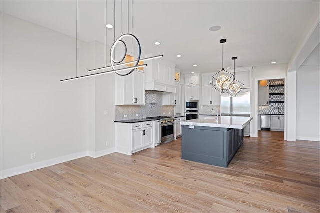 kitchen with light wood-type flooring, white cabinets, and built in appliances