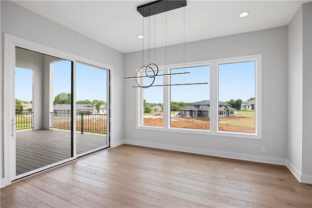 unfurnished dining area featuring recessed lighting, baseboards, and hardwood / wood-style floors