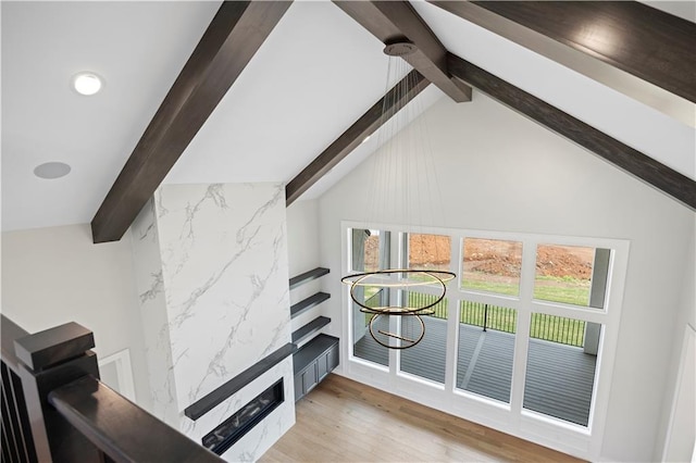 interior space featuring vaulted ceiling with beams and light wood-style flooring