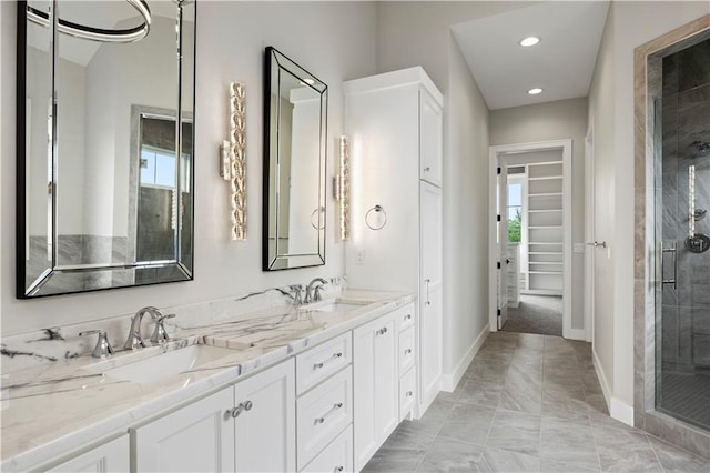 bathroom with a stall shower, plenty of natural light, a sink, and a walk in closet