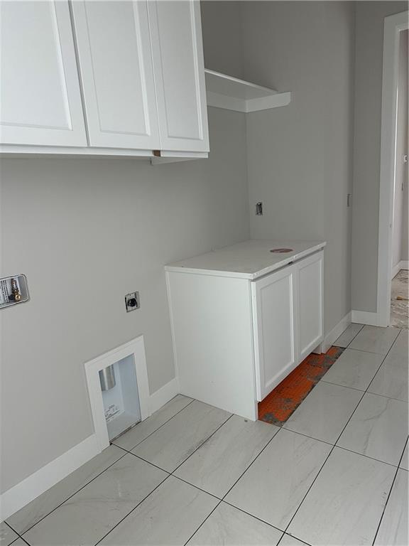 17321 Bluejacket St, Overland Park, KS 66221 - clothes washing area featuring electric dryer hookup, cabinet space, baseboards, and washer hookup