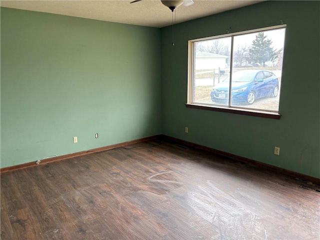 unfurnished room with a ceiling fan, a textured ceiling, baseboards, and wood finished floors