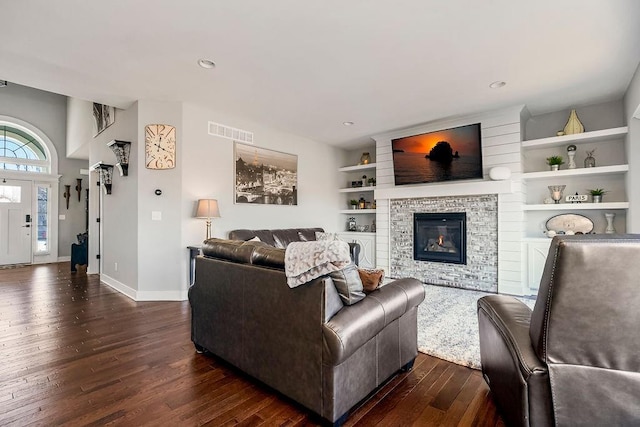 living area featuring visible vents, baseboards, recessed lighting, dark wood-style floors, and a glass covered fireplace